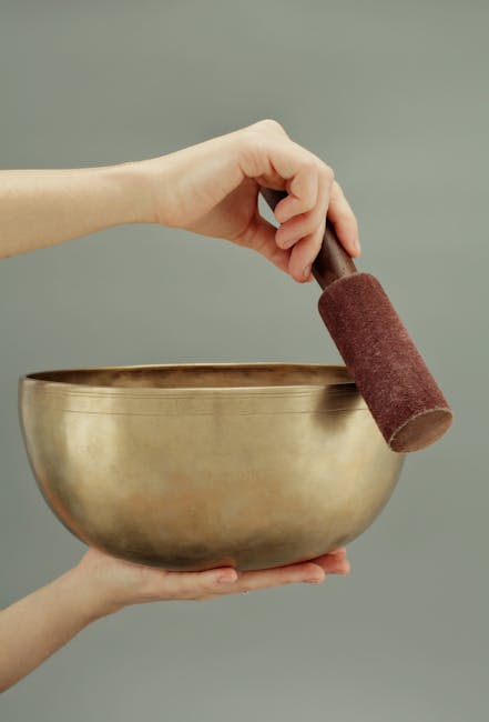 七大脈輪:頻率與音樂的療癒力量A close-up of hands holding a Tibetan singing bowl, used for sound healing and meditation.